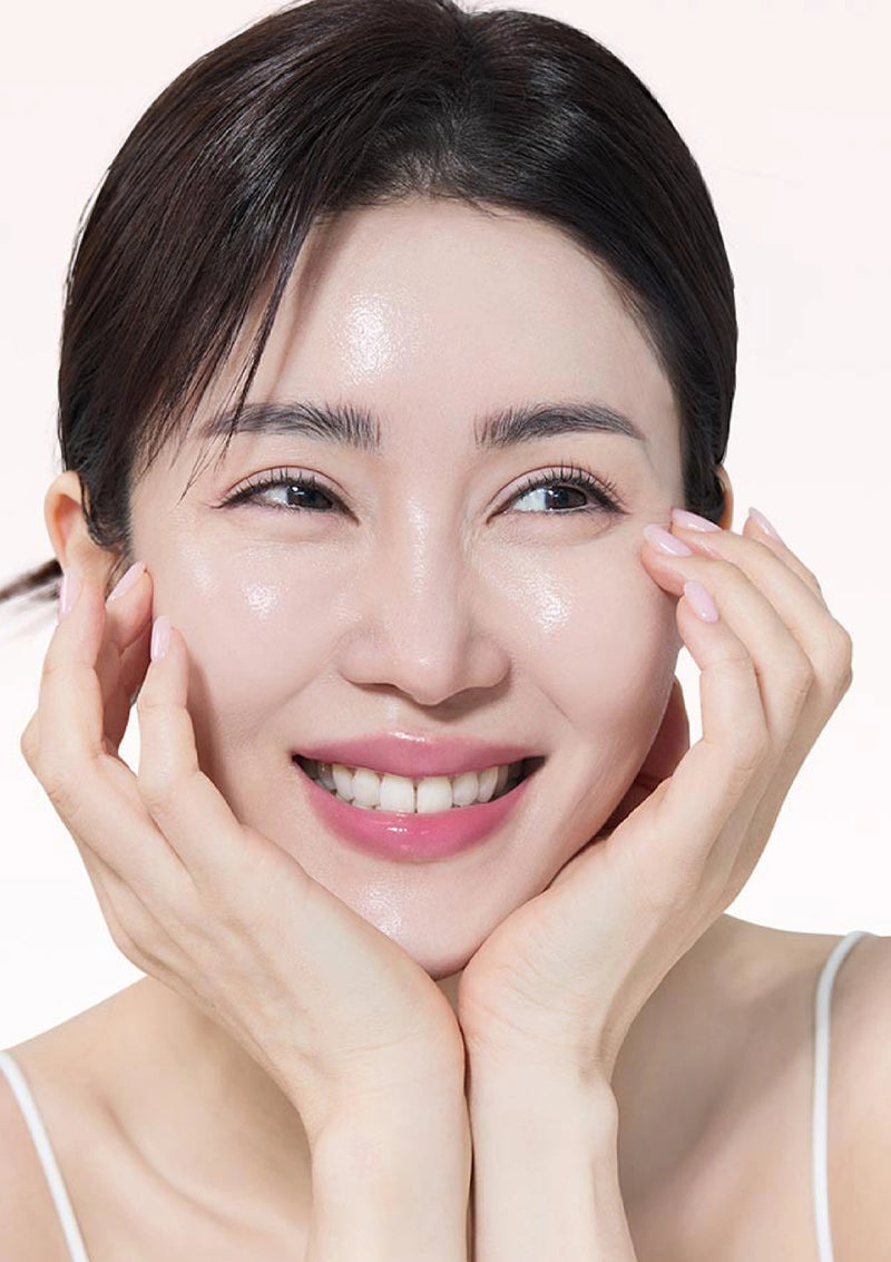 Woman with smooth skin touching her face against a white background