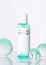 Skincare bottle with blue liquid and bubbles on a white background
