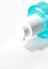 Blue and white bottle with a droplet of liquid on a white background