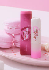 Two lip products, one pink and one white, with 'hola hola you' branding on a pink background.