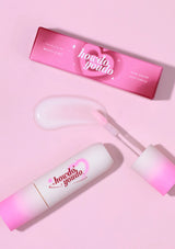 Pink skincare product with applicator and packaging on a pink background