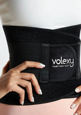 Black waist trainer with 'volexy' branding worn by a person on a light background