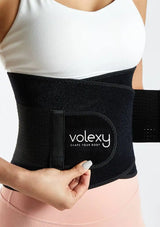 Black waist trainer with 'volexy' branding worn by a person on a light gray background