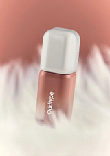 Nail polish bottle with a white cap and rose gold body on a soft pink and white background