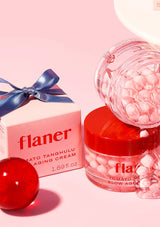 Flaner skincare product with red jar and pink packaging on a light pink background