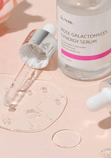 Rose Galactomyces Synergy Serum with dropper on a pink background