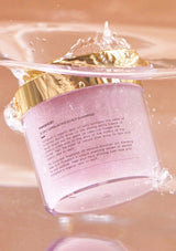 Pink jar of shampoo with gold cap on a pink background