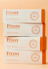 Stack of Fitany boxes on a peach background