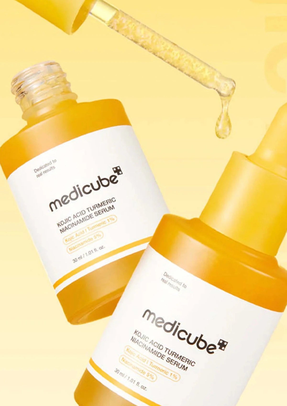 Two bottles of Medicube skincare serum on a yellow background