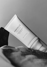 Tube of Centella Asiatica cream on a textured surface with a neutral background