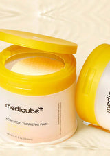 Open jar of Medicube Kojic Acid Turmeric Pad on a light background