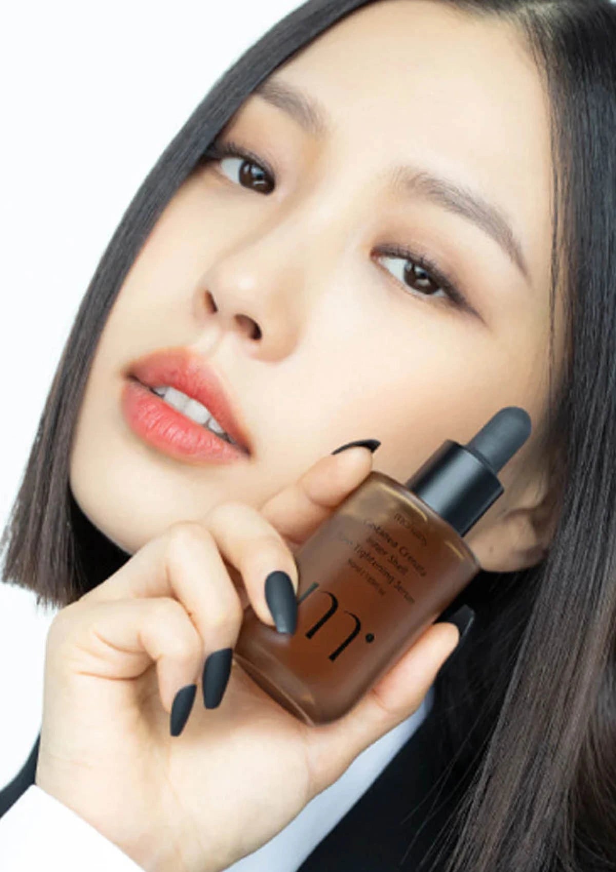 Woman holding a skincare bottle with a close-up of her face.