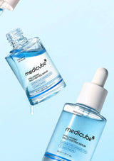 Two bottles of Medicube Hyaluronic Multi-Peptide Serum on a light blue background