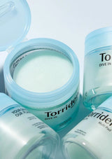 Torriden product with open jar and cap on a light blue background