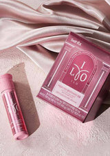 Pink ILOO product packaging and tube on a soft pink fabric background