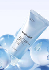Medicube skincare product with water droplets on a light blue background