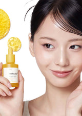 Woman holding a skincare product with yellow droplets on a white background