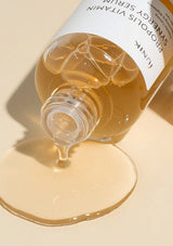 Serum bottle with dropper on a beige background