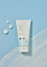 White tube of cream with blue label on a light blue background