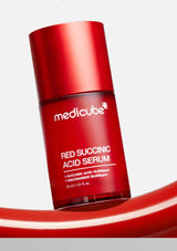 Red Succinic Acid Serum bottle with Medicube branding on a light gray background
