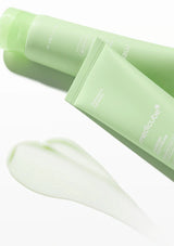 Two green skincare products with a smear of product on a white background