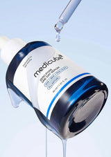 Medicube serum bottle with dropper on a light blue background