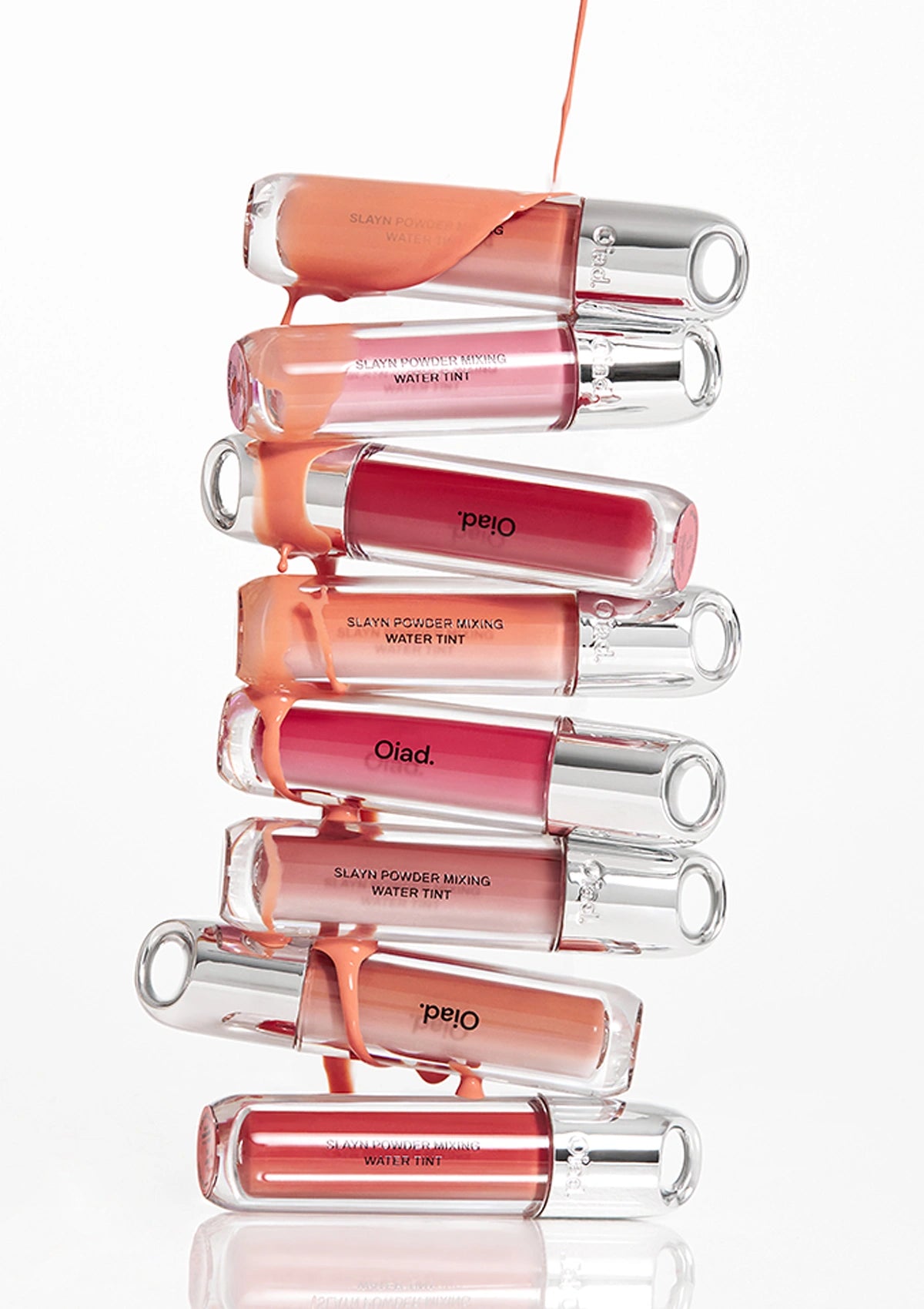 Eight OIAD Slayn Powder Mixing Water Tint bottles stacked to show the shade range
