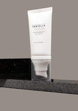 Skincare tube with brand name on a gray background
