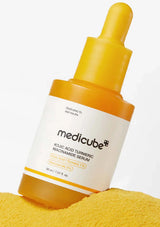 Medicube skincare serum bottle with yellow dropper on a white background