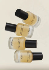 Four bottles of Yunjac skin perfecting protective base coat on a beige background