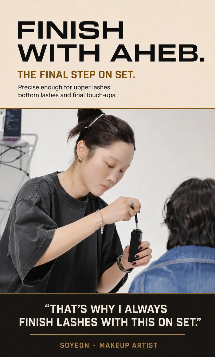 Professional makeup artist finishing upper and lower lashes with AHEB