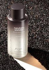 HARUHARU WONDER alcohol- and fragrance-free Black Rice Hyaluronic Toner with a dark cap among black rice grains