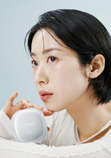 Woman holding a white device with a light blue background