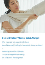 A woman in a white top is shown wearing or adjusting a cream-colored knit garment, with promotional text below about vitamin, cala, and mango fragrance notes.