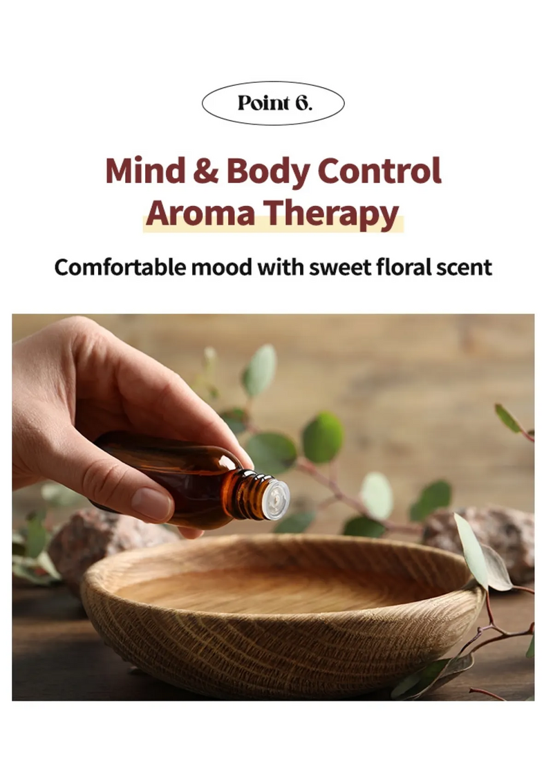 Hand holding a bottle of essential oil over a wooden bowl with leaves in the background, promoting aroma therapy.