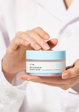 Person holding a jar of Unik skincare cream against a white background