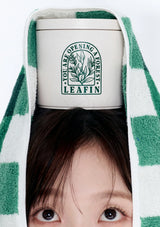 Person wearing a green and white checkered towel with a LEAFIN product on their head