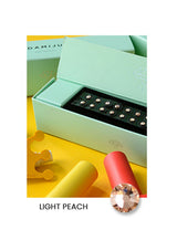 Light green jewelry box with a ring on a yellow surface, featuring the brand 'DAMJU'.