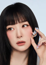 Woman holding a wireless earbud against a light blue background