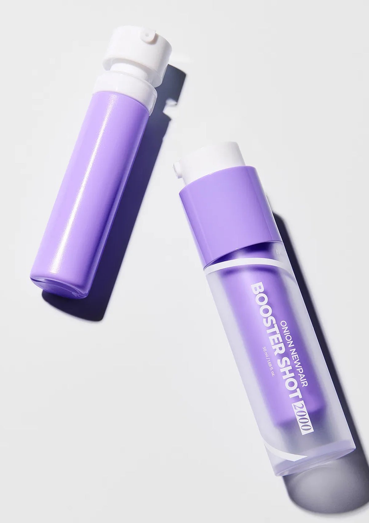 Two purple bottles with white caps on a light gray background