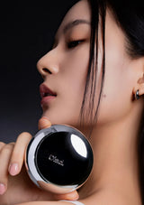 Woman holding a black compact mirror with 'Chanel' branding.