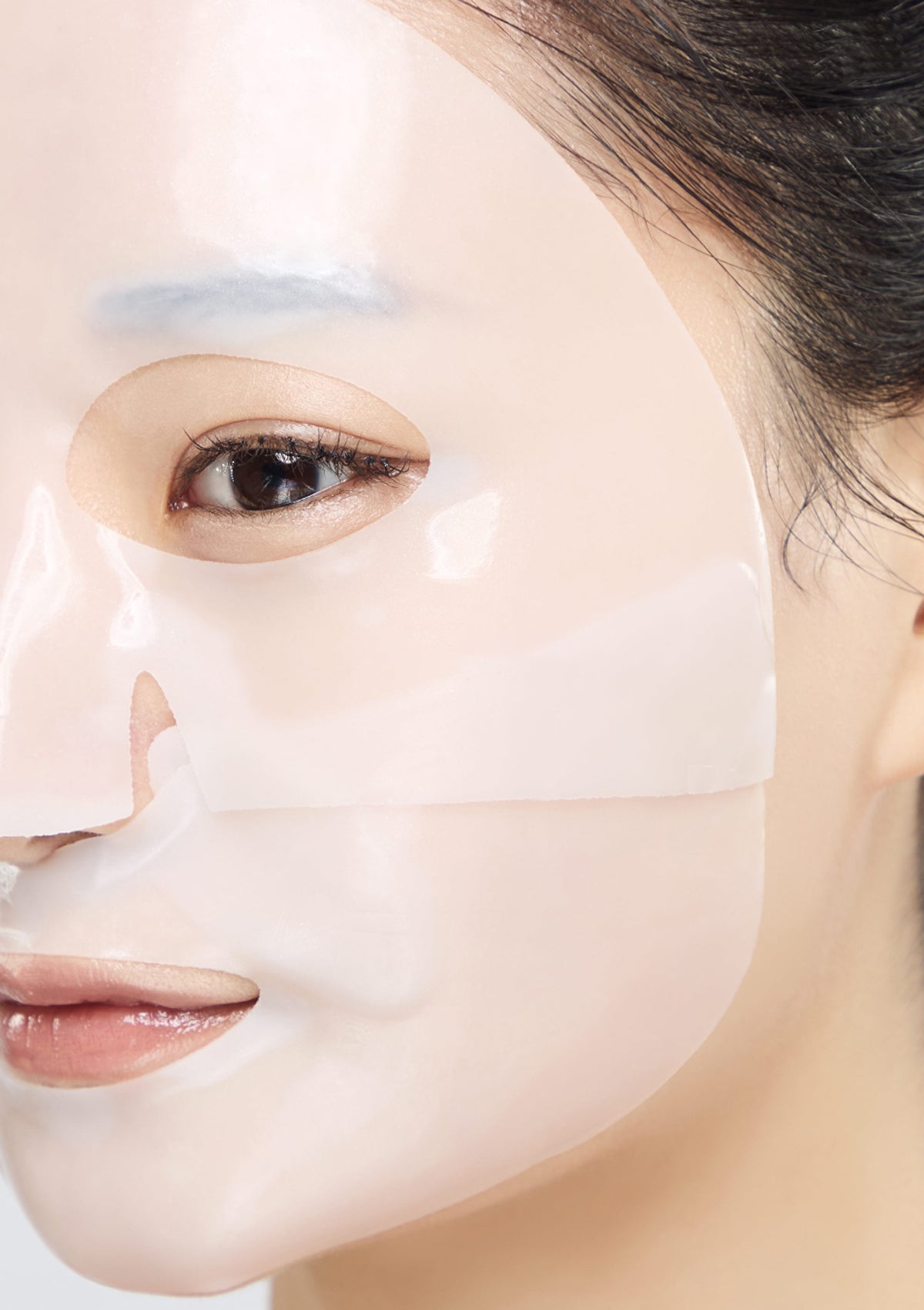 Close-up of a person wearing a face mask with a neutral background