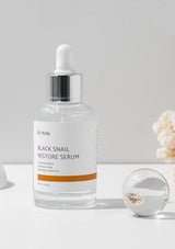 IUNIK Black Snail Restore Serum bottle on a light gray background