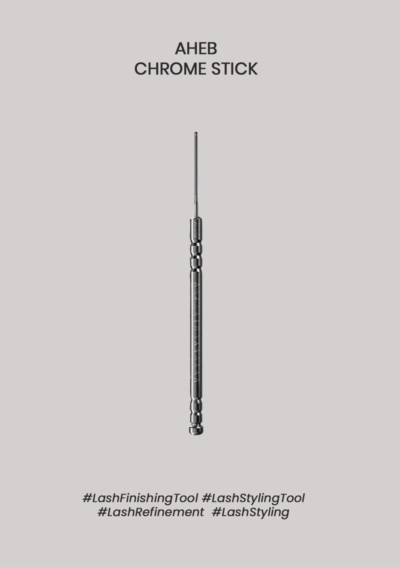 A single slim metallic lash styling tool is centered on a plain light gray background, with the text 'AHEB CHROME STICK' above it and hashtag-style labels below.