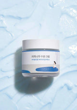 Jar of cream on a light blue textured background