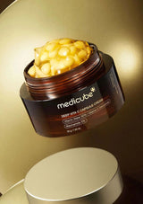 Medicube Deep Vita C Capsule Cream jar with cream visible on a gold background